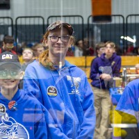 Three teammates smile in their work area